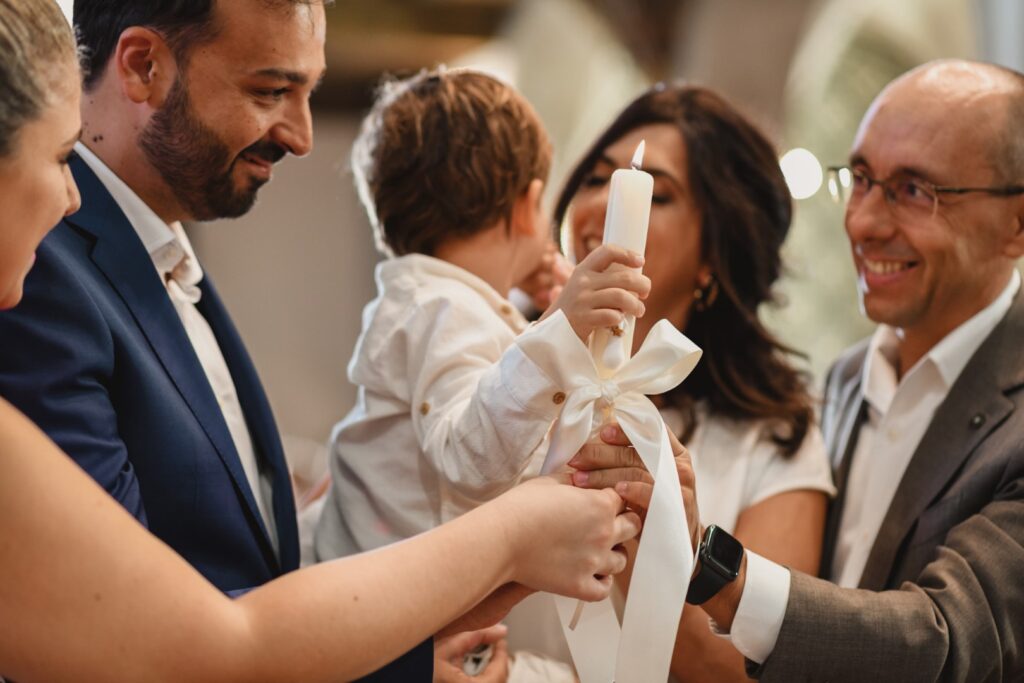 Fotografia de Batizado. Cerimónia na Igreja. Pais e padrinhos seguram a vela.