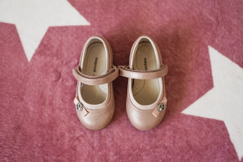 Fotografia de Batizado. Pormenor de sapatos de menina. Sessão em casa. Preparação.
