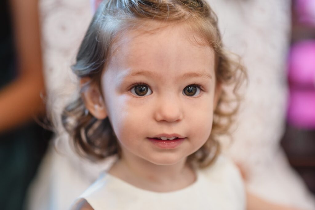 Fotografia de Batizado. Cerimónia na Igreja. Menina sorri.