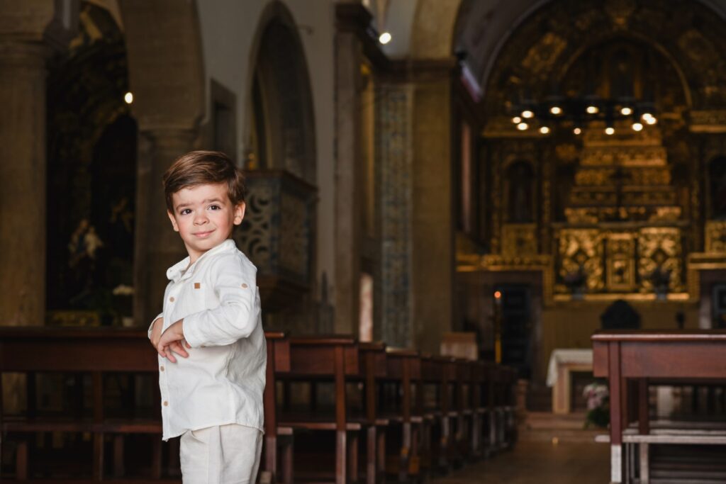 Fotografia de Batizado. Menino à porta da igreja.