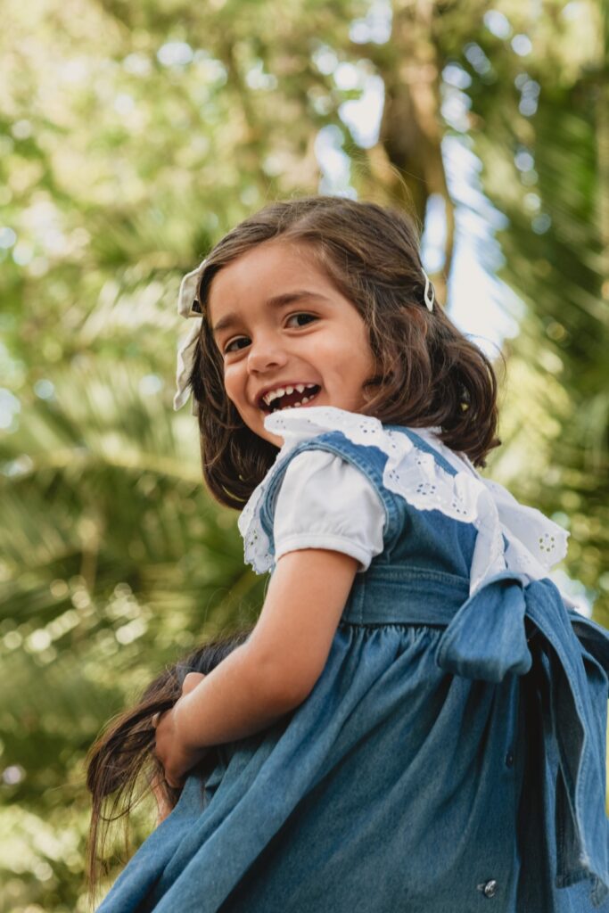 Sessões fotográficas de família. Sessões fotográficas em exterior, num jardim. Menina às cavalitas da Mãe.