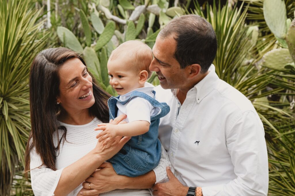 Sessões fotográficas de família. Sessões fotográficas em exterior, num jardim. Pais com o filho mais novo.