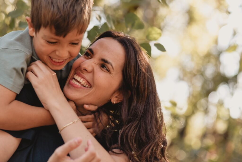 Sessões fotográficas de família. Sessões fotográficas em exterior, na natureza. 
Mãe faz cocegas a filho.