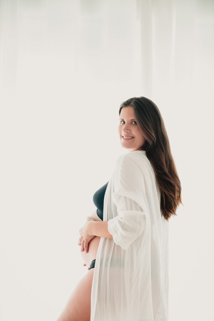 Sessões fotográficas gravidez. Mulher grávida feliz. Sessões fotográficas de gravidez em casa.